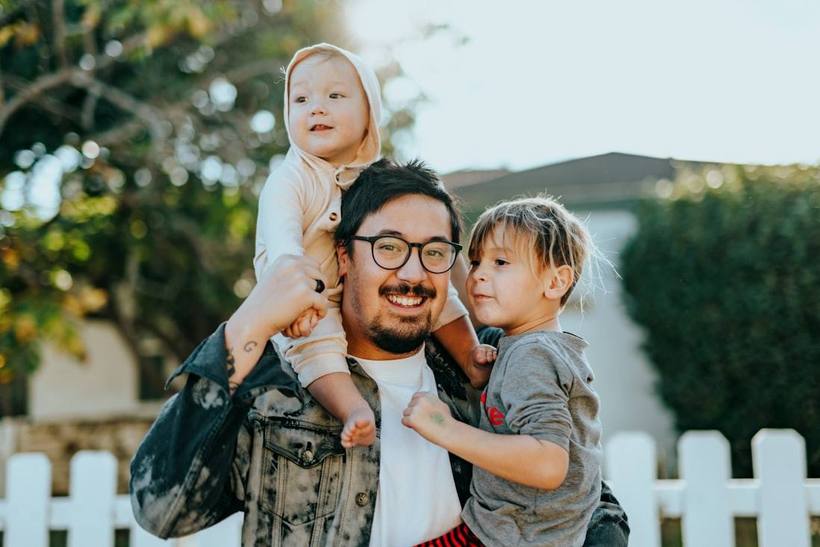 Padre jugando al aire libre con sus dos hijos